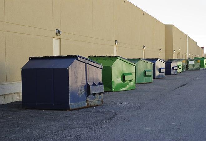 a row of yellow and blue dumpsters at a construction site in Algonquin